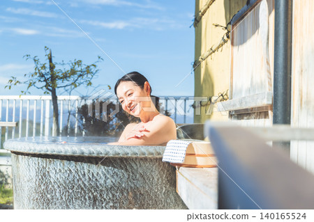 一位女士在露天浴池中放鬆 140165524