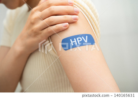 HPV, Human papillomavirus, Asian young woman receiving vaccine with blue bandage. 140165631