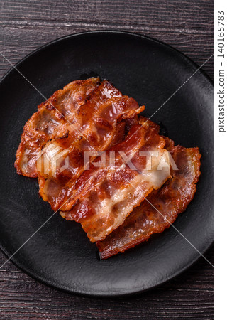 Fried fresh bacon slices with layers of meat or prosciutto with salt and spices. Fried bacon 140165783
