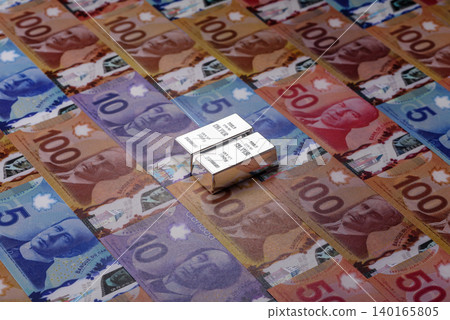 A silver bar, white metal against a backdrop of Canadian money, as a concept. A silver bar A silver bar, white metal against a backdrop of Canadian money, as a concept. A silver bar 140165805