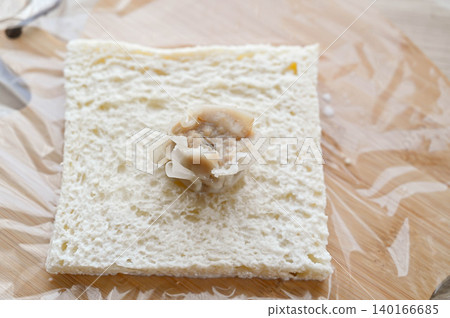 The cooking process involves placing the shumai on a moistened slice of bread. The cooking process involves placing the shumai on a moistened slice of bread. 140166685