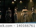 Mannequins lined up in shop windows at night 140166761