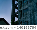 The twilight sky and the exterior staircase of an old apartment complex. 140166764