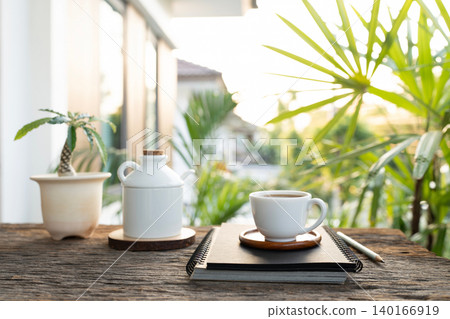 White coffee cup and plant pot and notebook 140166919