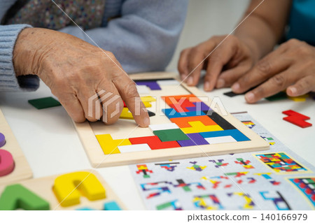 Asian elderly woman playing game with caregiver for train memory. Asian elderly woman playing game with caregiver for train memory. 140166979