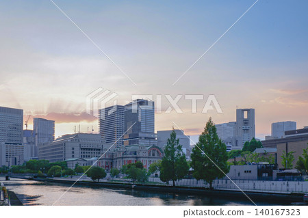 夕陽的暮光映照著大阪中之島公會堂和摩天大樓的輪廓,景色美不勝收。 夕陽的暮光映照著大阪中之島公會堂和摩天大樓的輪廓,景色美不勝收。 140167323