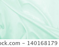 Smooth elegant green silk or satin luxury cloth texture as abstract background. Luxurious background design 140168179
