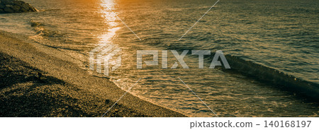 Golden sun path on the pebble beach at sunset. Nice, France, Europe Golden sun path on the pebble beach at sunset. Nice, France, Europe 140168197