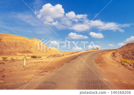 Driving a car on a mountain road in the desert. View of sandstone mountains through the windscreen. Timna Park, Israel Driving a car on a mountain road in the desert. View of sandstone mountains through the windscreen. Timna Park, Israel 140168208