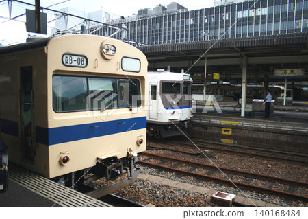 停泊在廣島車站的山陽本線 115 系列和 103 系列列車 140168484