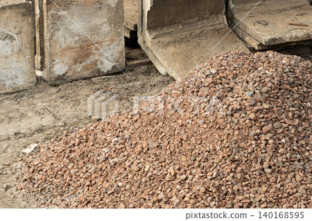 Construction gravel pile, crushed grey stone on ground Construction gravel pile, crushed grey stone on ground 140168595