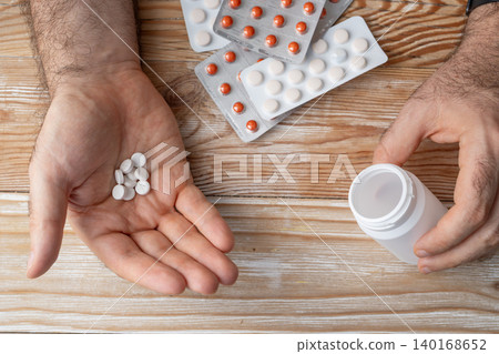 Pills in hand top view, taking painkillers, white medical tablets Pills in hand top view, taking painkillers, white medical tablets 140168652