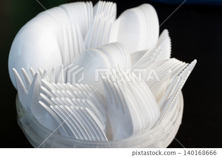 Disposable plastic cutlery closeup, macro photo of white plastic forks, knifes and spoons Disposable plastic cutlery closeup, macro photo of white plastic forks, knifes and spoons 140168666