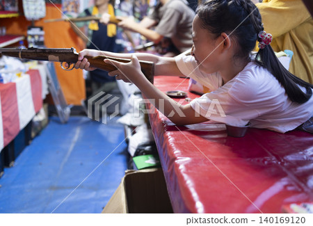 Children enjoying shooting games at a festival. Children enjoying shooting games at a festival. 140169120