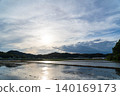 靜岡縣的逆光景色，日落時分，天空、雲彩和太陽倒映在稻田中。 140169173