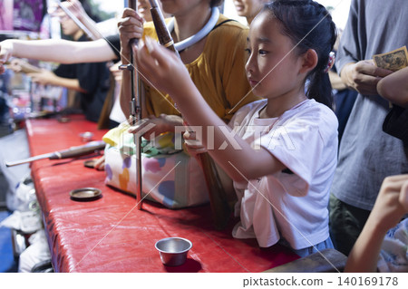 Children enjoying shooting games at a festival. Children enjoying shooting games at a festival. 140169178