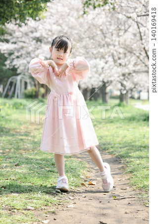 Cherry blossoms in full bloom and a girl in a pink dress Cherry blossoms in full bloom and a girl in a pink dress 140169418