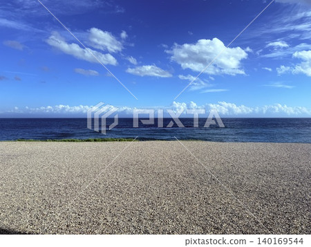 A scene of a blue sky, a vast ocean, and a tranquil pebble beach. A scene of a blue sky, a vast ocean, and a tranquil pebble beach. 140169544