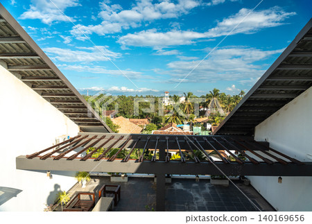 View of old tiled roofs and lush tropical greenery, editorial image 140169656