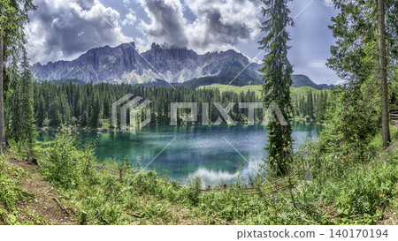 The emerald green Lake Carezza reflecting Latemar mountain, Dolomites, Italy The emerald green Lake Carezza reflecting Latemar mountain, Dolomites, Italy 140170194