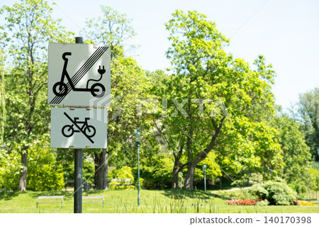 No electric scooters and no bicycles sign in a green public park No electric scooters and no bicycles sign in a green public park 140170398