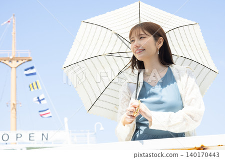 成人假期，最適合撐著遮陽傘，沐浴在藍天白雲下。 140170443