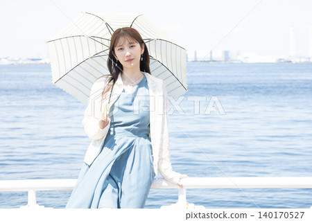 一位女子漫步街頭,享受著初夏的微風。 一位女子漫步街頭,享受著初夏的微風。 140170527