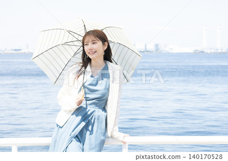 一位女子漫步街頭，享受著初夏的微風。 140170528