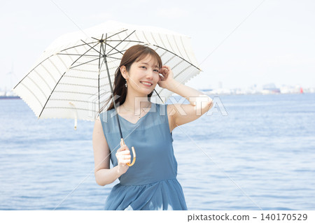 一位女子漫步街頭，享受著初夏的微風。 140170529