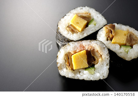 Eel sushi roll photographed against a black background Eel sushi roll photographed against a black background 140170558