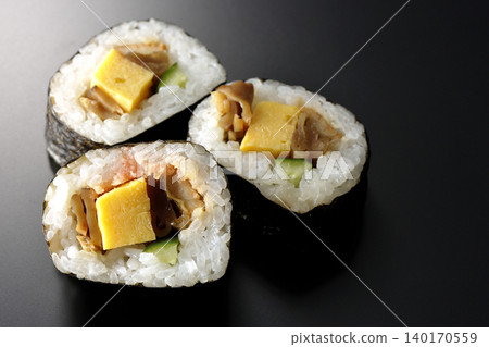 Eel sushi roll photographed against a black background 140170559