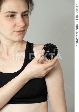 Woman Holding Spiky Massage Ball for Muscle Therapy Woman Holding Spiky Massage Ball for Muscle Therapy 140170616