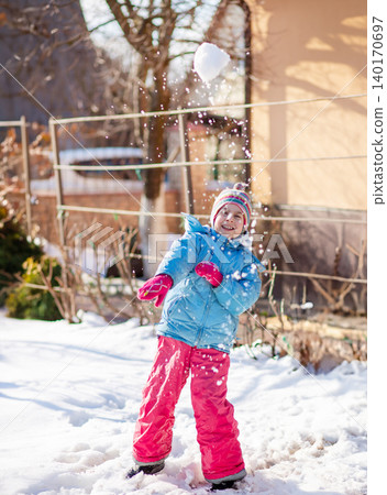 Smiling child in colorful winter clothes standing on snow Smiling child in colorful winter clothes standing on snow 140170697