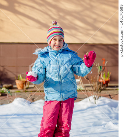 Smiling child in colorful winter clothes standing on snow Smiling child in colorful winter clothes standing on snow 140170699