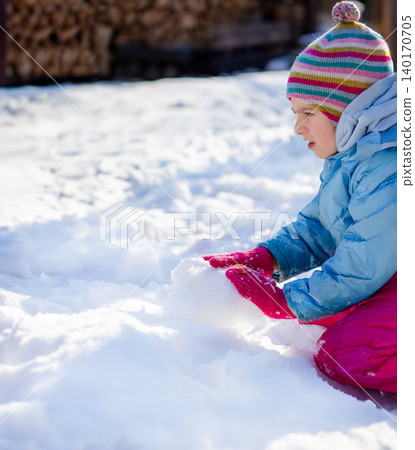 Smiling child in colorful winter clothes standing  140170705
