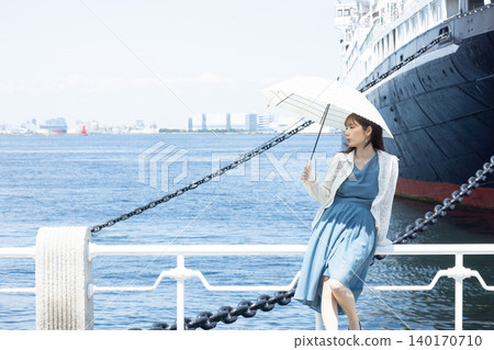 一位神采奕奕的女子撐著陽傘，沿著橫濱海濱漫步。 140170710