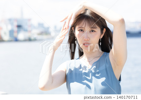 初夏的陽光下，一位女士面帶微笑。 140170711