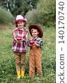 Two smiling children holding fresh red apples orchard baskets grass during sunny autumn harvest 140170740