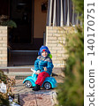 Little boy in blue jacket and funny shark hat riding toy car  140170751
