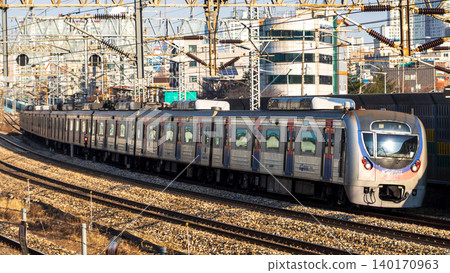 一列典型的韓國通勤列車（KORAIL）正在城市地區行駛。 140170963