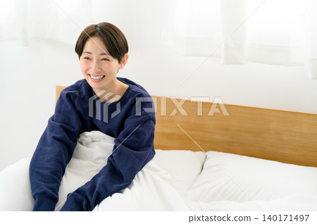 Japanese woman wakes up in bed Japanese woman wakes up in bed 140171497