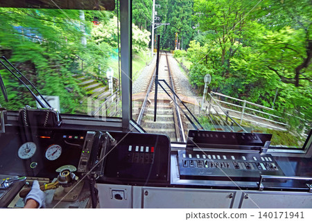 View from train driver's cabin on a scenic railway journey through lush green forest 140171941