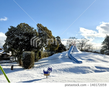 清晨,白雪皚皚的公園裡,山坡上有個溜滑梯。 清晨,白雪皚皚的公園裡,山坡上有個溜滑梯。 140172059