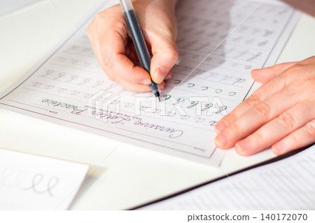Close up of woman hand training handwriting. Activation of unique cognitive and motor circuits, enhancing memory retention, focus and deep concentration concept Close up of woman hand training handwriting. Activation of unique cognitive and motor circuits, enhancing memory retention, focus and deep concentration concept 140172070
