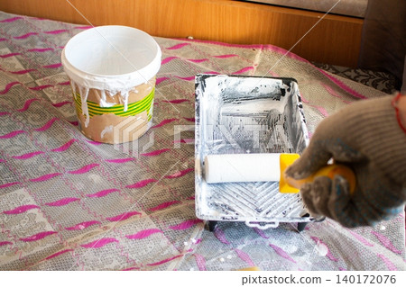 Hand dipping roller into paint tray. Spring home refresh. Budget friendly transformation. Small improvements, big mood boost. Smart spending Hand dipping roller into paint tray. Spring home refresh. Budget friendly transformation. Small improvements, big mood boost. Smart spending 140172076