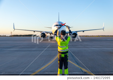 Aircraft marshalling at the aiport. Passenger airplane meeting Aircraft marshalling at the aiport. Passenger airplane meeting 140172095