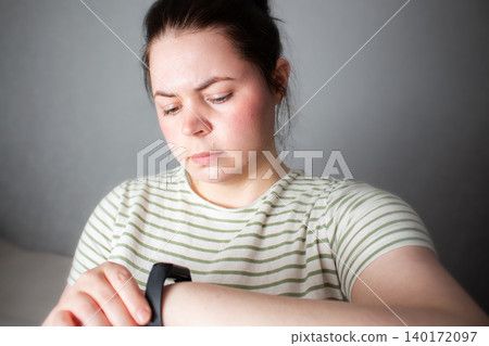 Woman checks health indicators using tracking app on smartwatch. Smart health means using devices as assistants not overlords. Low alarm high-awareness living. Digital detox concept Woman checks health indicators using tracking app on smartwatch. Smart health means using devices as assistants not overlords. Low alarm high-awareness living. Digital detox concept 140172097
