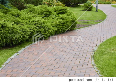 Winding path adorned with lush greenery in a tranquil park setting Winding path adorned with lush greenery in a tranquil park setting 140172151