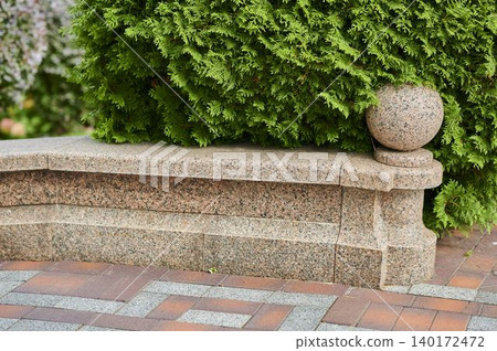 Beautiful park setting with a stone bench and lush greenery Beautiful park setting with a stone bench and lush greenery 140172472