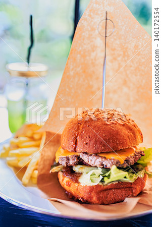 A hamburger with freshly baked buns and a thick patty. A hamburger with freshly baked buns and a thick patty. 140172554